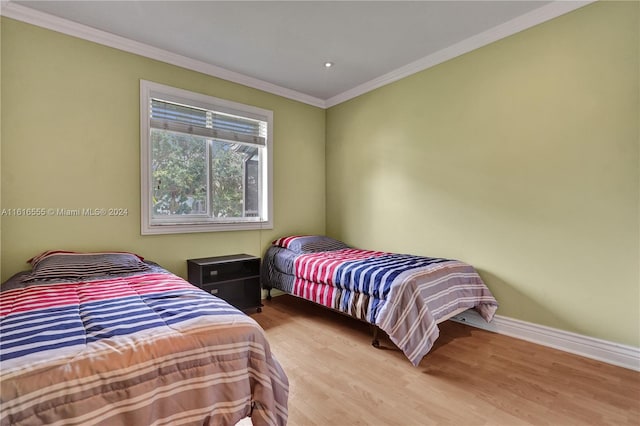 bedroom with wood-type flooring and crown molding