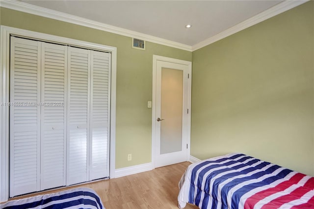 bedroom featuring a closet, hardwood / wood-style floors, and ornamental molding