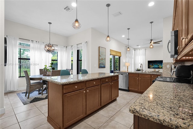 kitchen featuring plenty of natural light, a kitchen island, and ceiling fan with notable chandelier