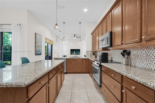 kitchen featuring plenty of natural light, a center island, stainless steel appliances, and ceiling fan