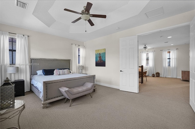 bedroom featuring a tray ceiling, ceiling fan, and light colored carpet