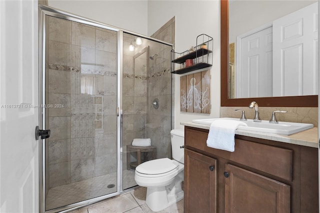 bathroom featuring tile patterned flooring, vanity, toilet, and an enclosed shower