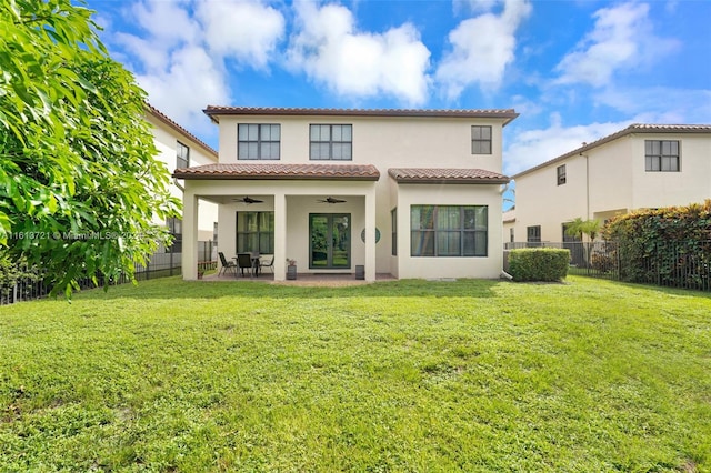 rear view of house with a patio, ceiling fan, and a lawn