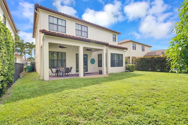 back of property featuring a lawn, a patio area, and ceiling fan