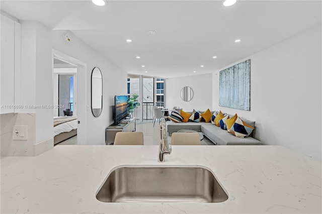 kitchen featuring sink and light stone counters