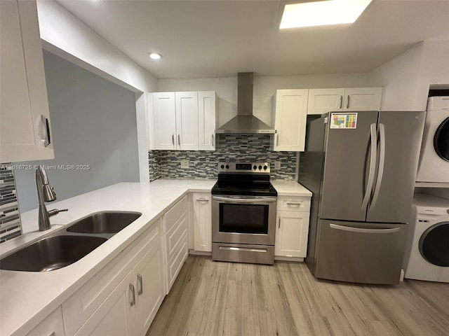 kitchen with white cabinets, stainless steel appliances, and wall chimney exhaust hood