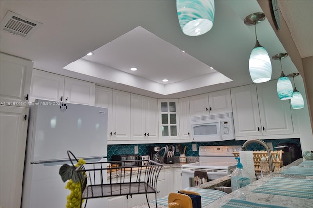 kitchen featuring white cabinets, white appliances, and a tray ceiling