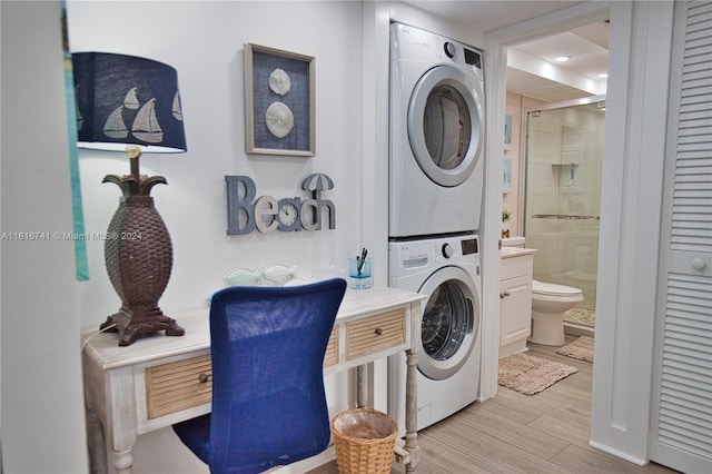 washroom with stacked washer and dryer and light hardwood / wood-style floors