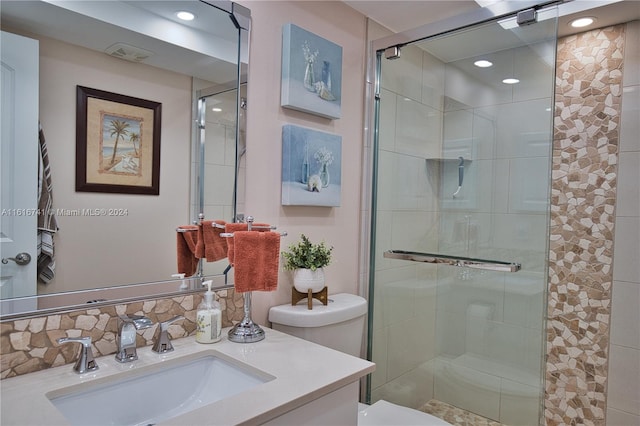 bathroom featuring walk in shower, vanity, and toilet