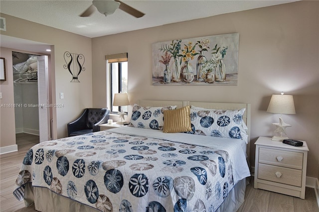 bedroom with ceiling fan, a textured ceiling, a closet, and light wood-type flooring