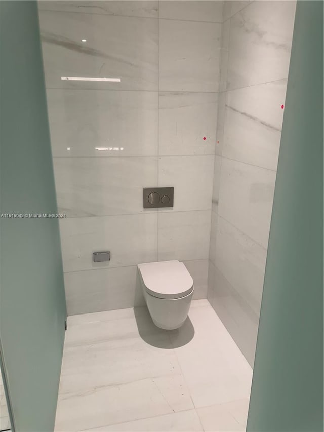 bathroom featuring tile walls, toilet, and tile patterned flooring