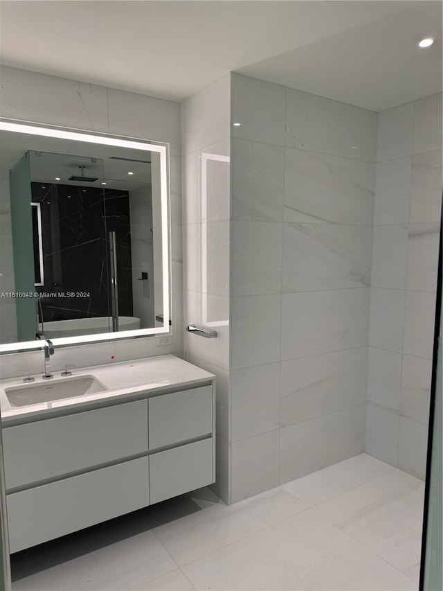 bathroom featuring vanity, tiled shower, and tile patterned flooring