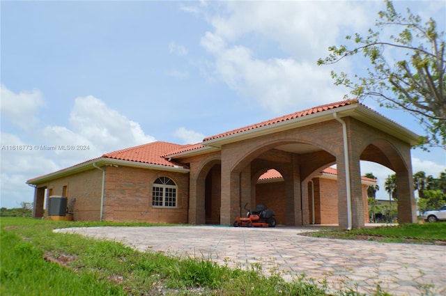 31002 SW 212th Ave, Homestead, FL 33030 - back of house featuring a tile roof, central air condition unit, and brick siding