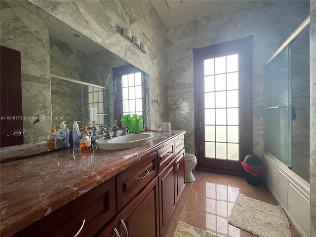 bathroom with vanity, toilet, and a healthy amount of sunlight