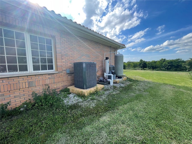 31002 SW 212th Ave, Homestead, FL 33030 - view of property exterior featuring brick siding, central AC unit, and a lawn