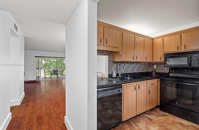 kitchen featuring backsplash, a textured ceiling, sink, black appliances, and dark hardwood / wood-style floors