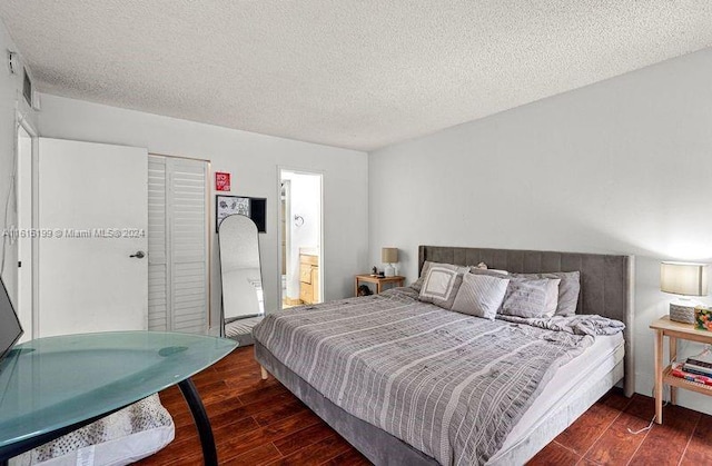 bedroom with a textured ceiling and connected bathroom