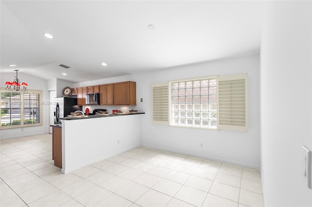 kitchen featuring black fridge, light tile patterned flooring, and vaulted ceiling