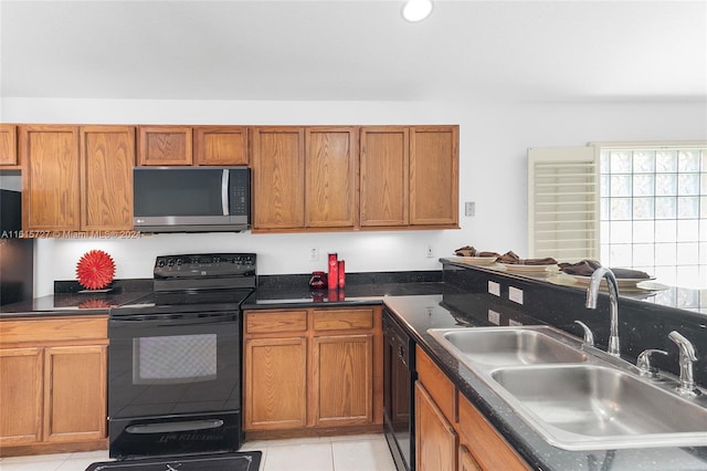 kitchen featuring light tile patterned floors, black appliances, and sink