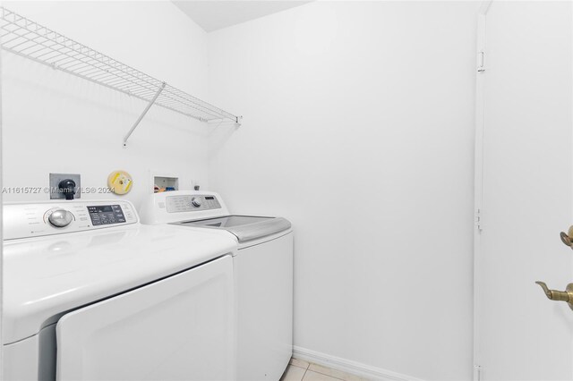 washroom with washing machine and clothes dryer and light tile patterned floors