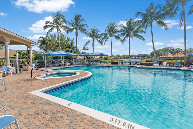 view of pool with a hot tub and a patio area