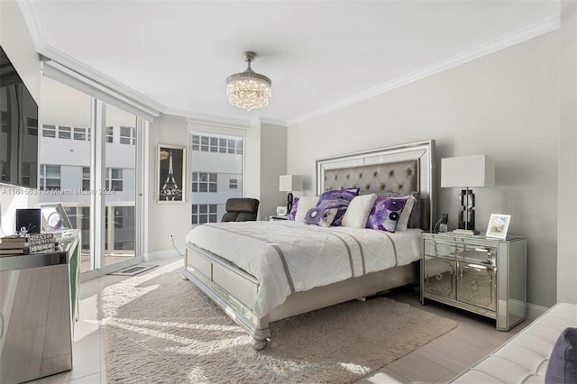 bedroom featuring light hardwood / wood-style flooring, crown molding, and an inviting chandelier