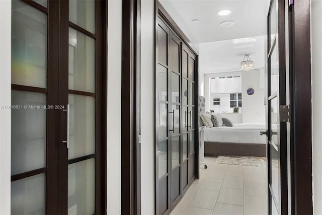 hallway featuring french doors and an inviting chandelier