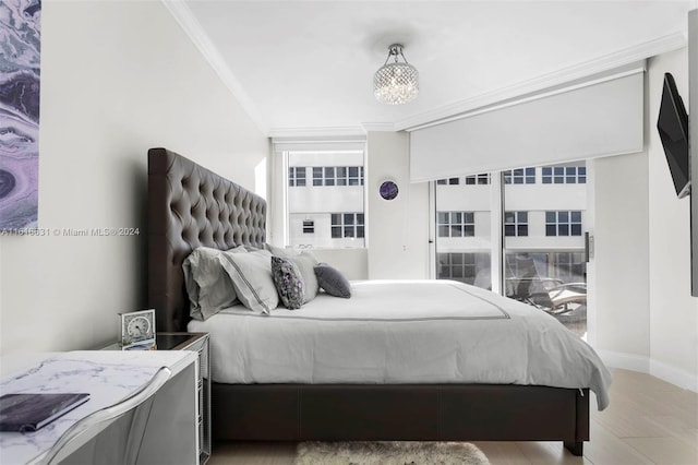 bedroom with light wood-type flooring and ornamental molding