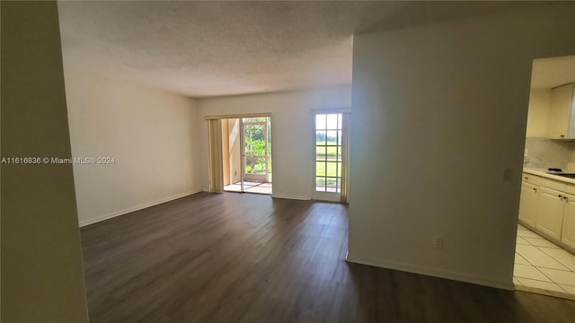 unfurnished room featuring light wood-type flooring and a textured ceiling