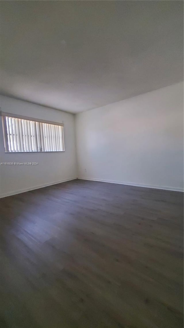 unfurnished room with dark wood-type flooring