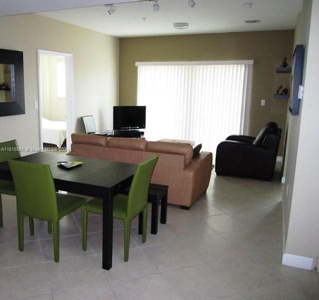 tiled dining space featuring a healthy amount of sunlight