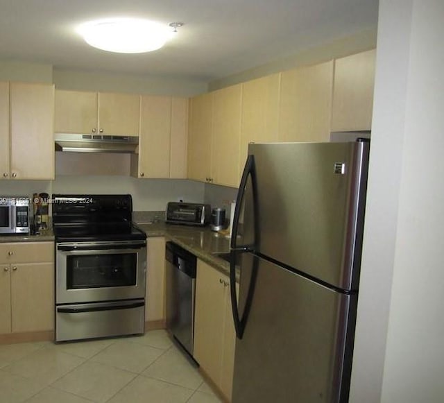 kitchen featuring light tile patterned flooring, cream cabinetry, and appliances with stainless steel finishes