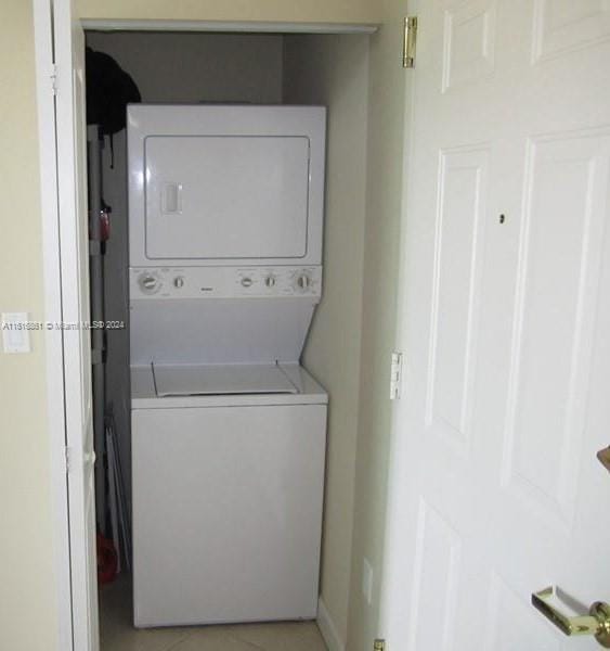 washroom featuring stacked washer / drying machine