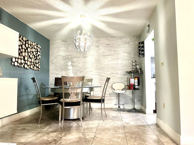 dining area featuring a textured ceiling, a chandelier, and light tile patterned floors