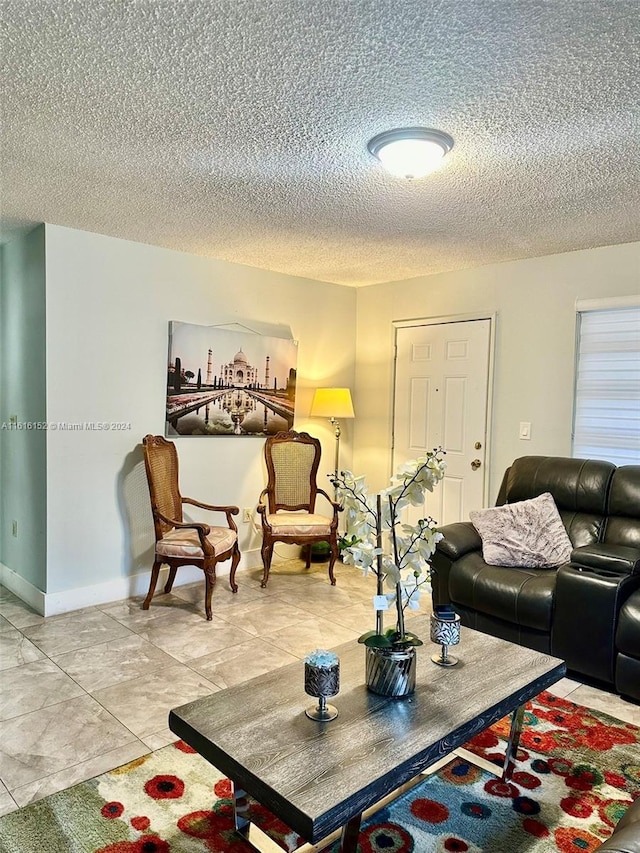 living room with light tile patterned flooring and a textured ceiling