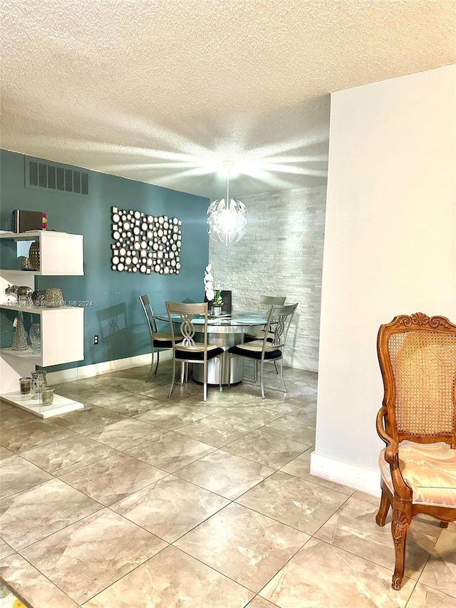 tiled dining room with a textured ceiling and a chandelier