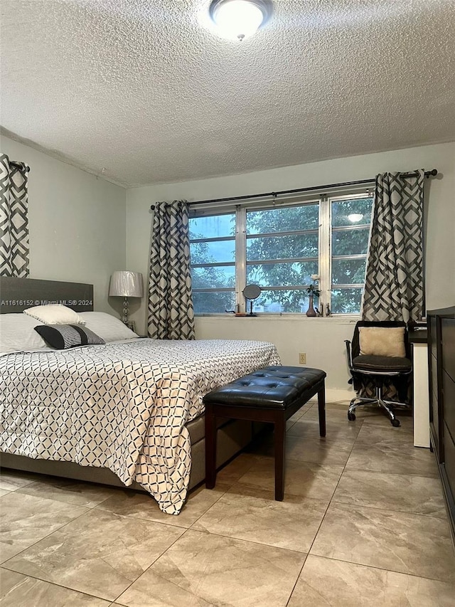 tiled bedroom featuring a textured ceiling