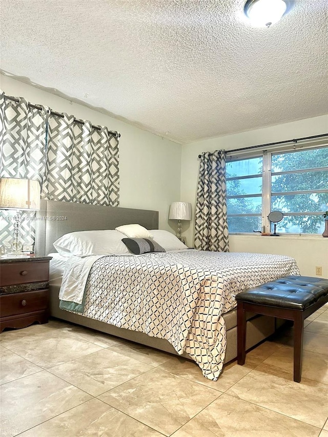 bedroom with a textured ceiling and light tile patterned flooring