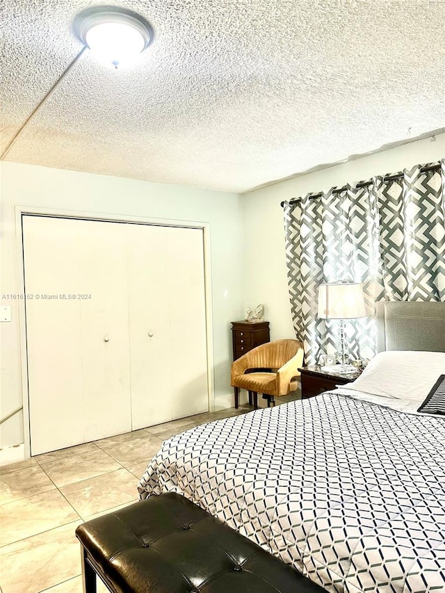 tiled bedroom featuring a closet and a textured ceiling