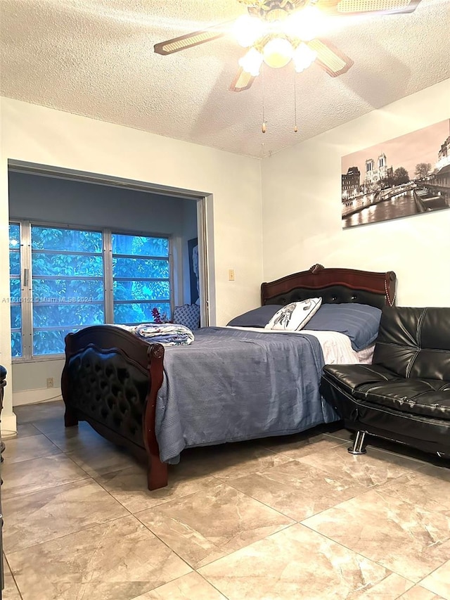 tiled bedroom featuring ceiling fan and a textured ceiling