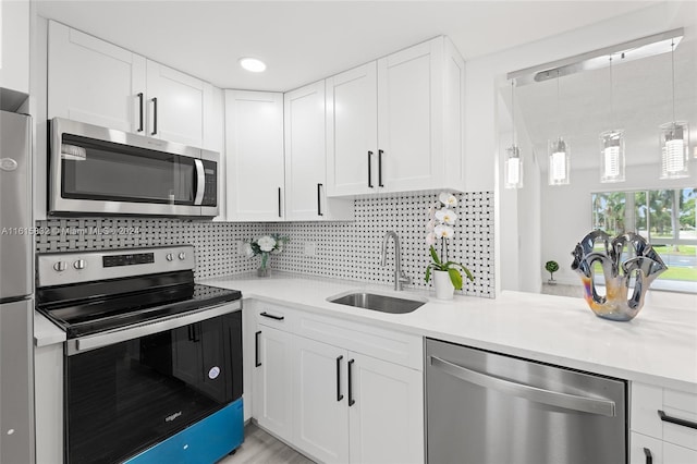 kitchen with white cabinetry, stainless steel appliances, sink, and tasteful backsplash