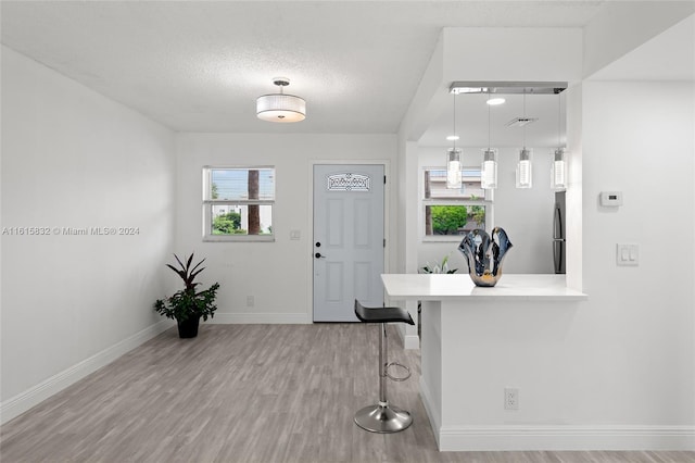 foyer featuring a textured ceiling and light hardwood / wood-style flooring