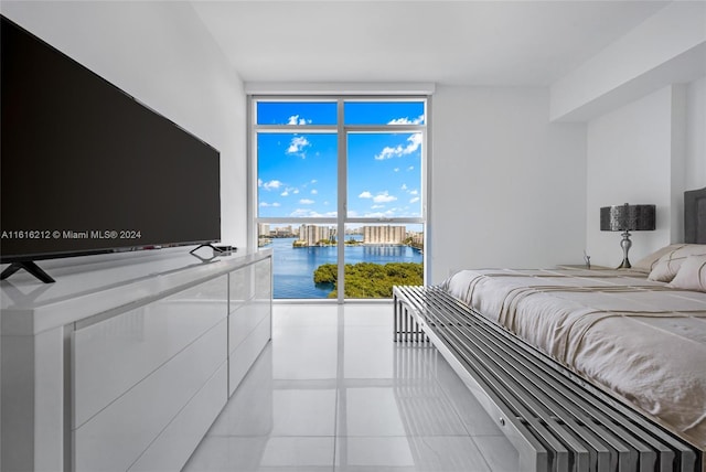 bedroom featuring light tile patterned floors and a wall of windows