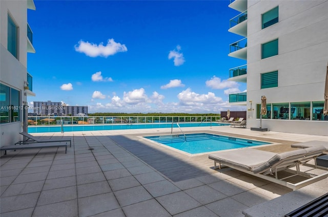 view of swimming pool featuring tennis court