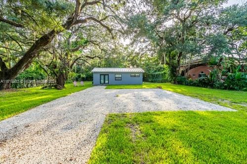 view of front facade featuring an outbuilding and a front lawn