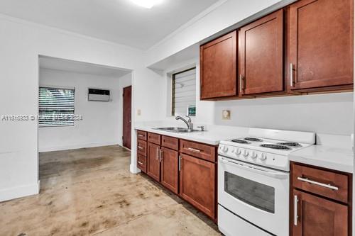 kitchen with sink, white gas stove, concrete flooring, and crown molding