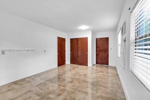 unfurnished bedroom with a closet and concrete flooring