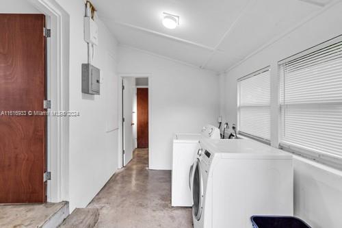 clothes washing area featuring electric panel and independent washer and dryer