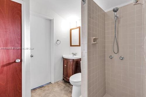 bathroom featuring tiled shower, vanity, toilet, and tile patterned floors