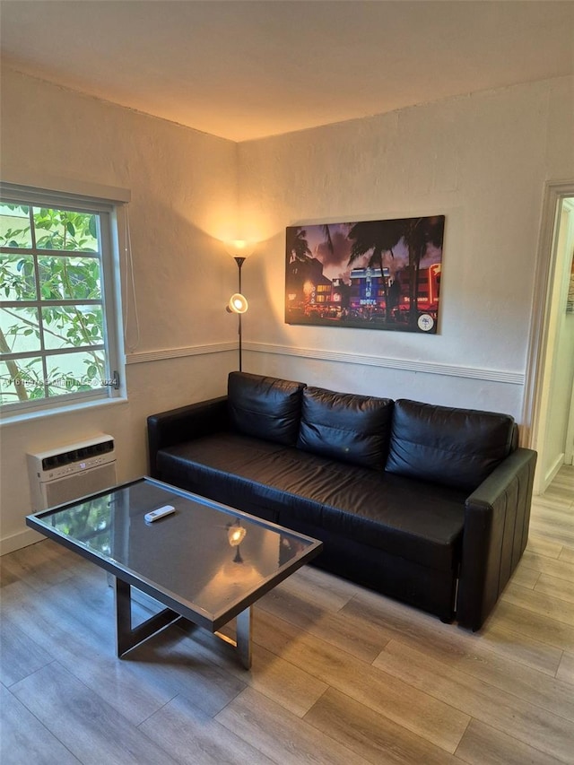 living room featuring light hardwood / wood-style flooring and a wall mounted air conditioner